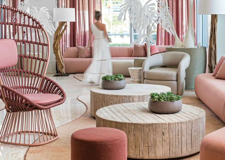 A hotel lobby with pale pink furnishings by BHDM Design