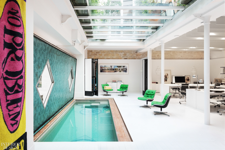 A pool in a Paris office surrounded by green chairs