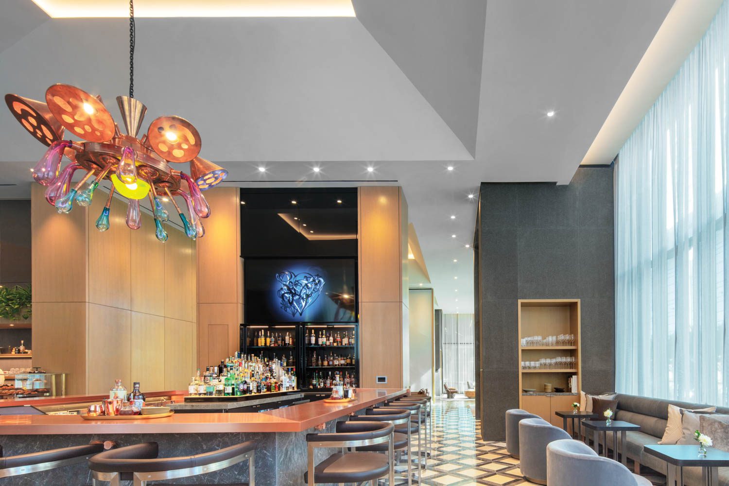 Misha Kahn’s glass-and-copper chandelier presides over the lobby bar. Photography by Eric Laignel.