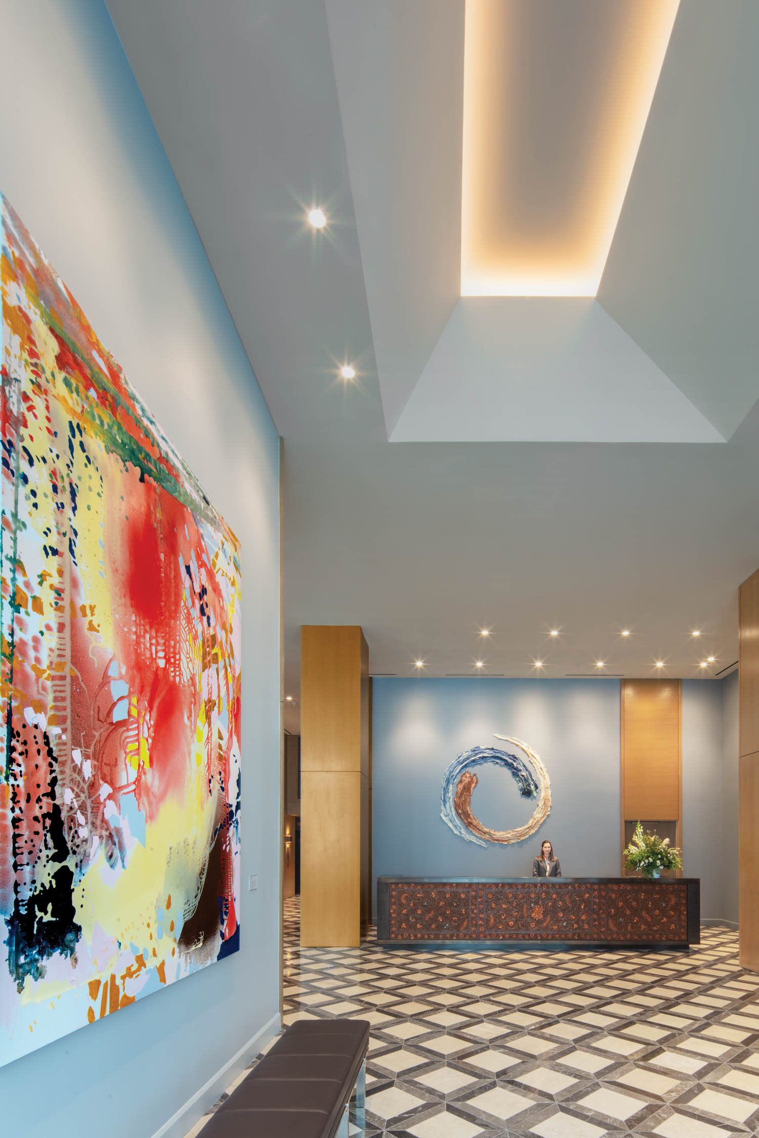 The lobby’s coffered ceiling and Turkish marble floor pattern echo the geometric shapes of the facade; the oil on linen is by Saccoccio, the stoneware swirl by Brie Ruais. Photography by Eric Laignel.