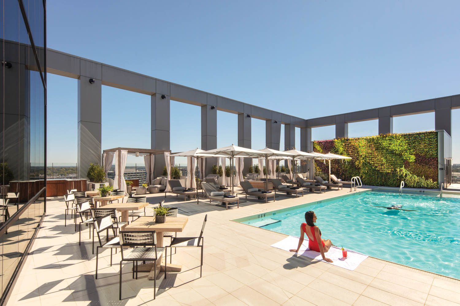 Peg Woodworking dining chairs populate the rooftop pool’s porcelain-tile deck. Photography by Eric Laignel.