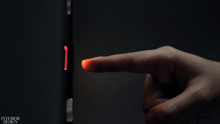 a person points their finger at a button in an elevator