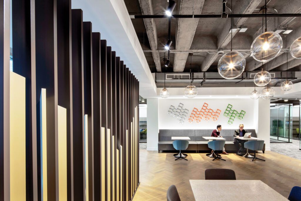 A slatted painted-metal screen similar to reception’s flanks the social hub, where the herringbone flooring is white oak.