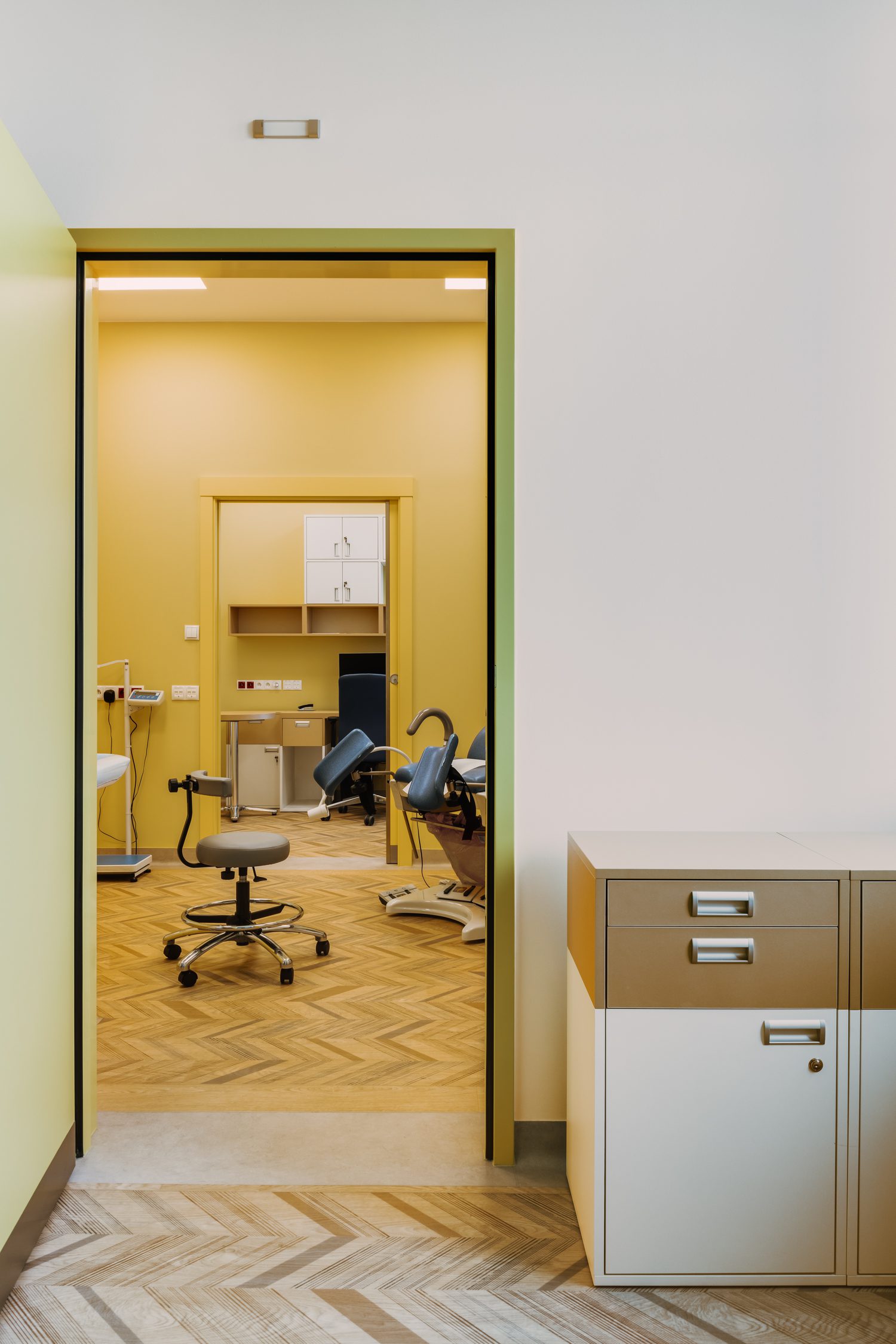 Patient treatment rooms have herringbone faux wood floors—actually rendered in homogeneous surfacing by Gerflor.