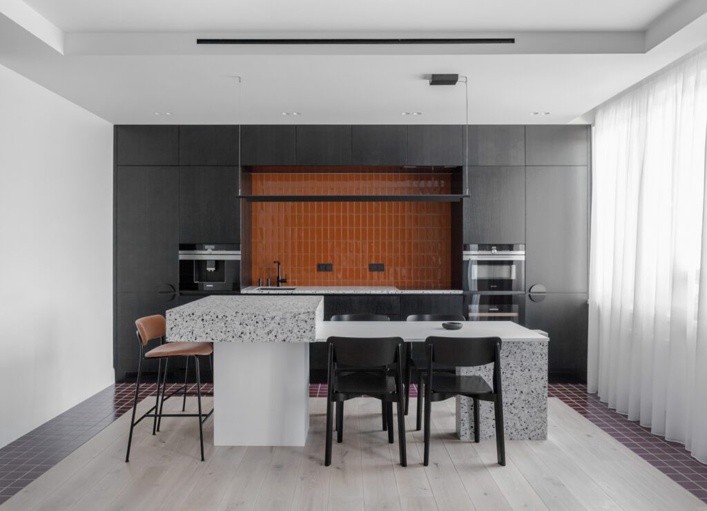 The wine tiles in the kitchen are mirrored in the living area, but in an inverse pattern.