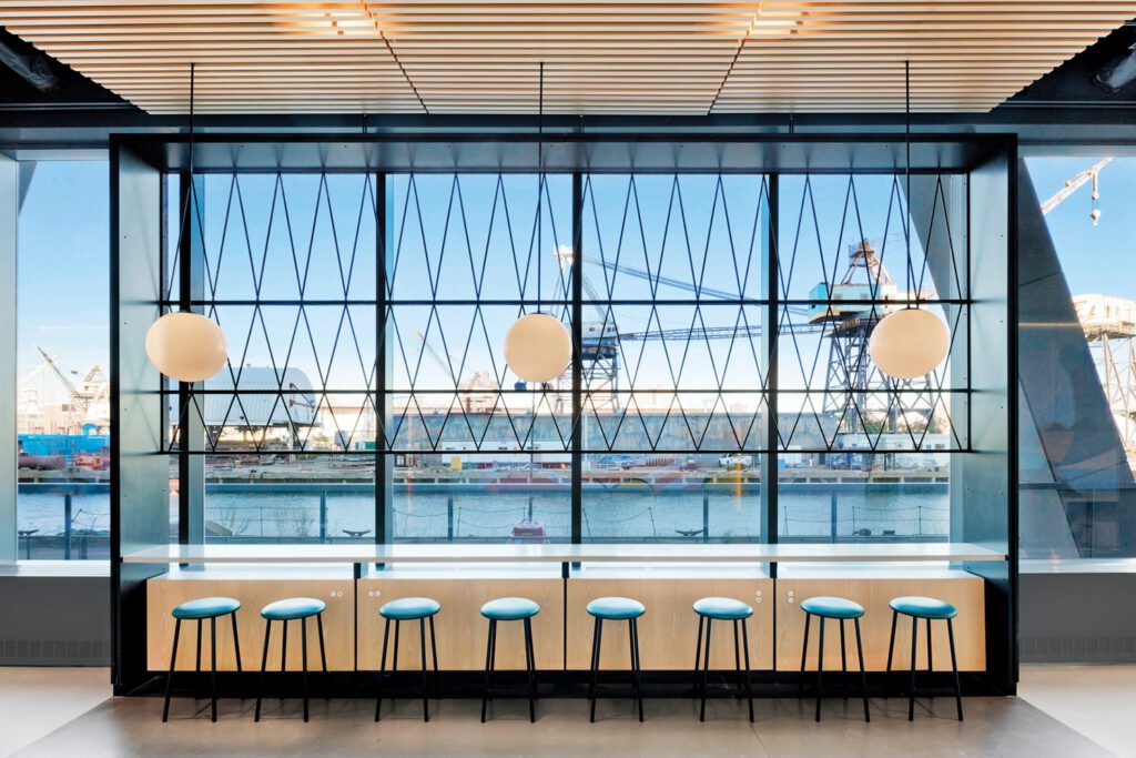 Farther down the corridor, a custom steel screen joins Andrew Neyer’s Astro pendant globes and Sputnik stools by Mattias Ljunggren.