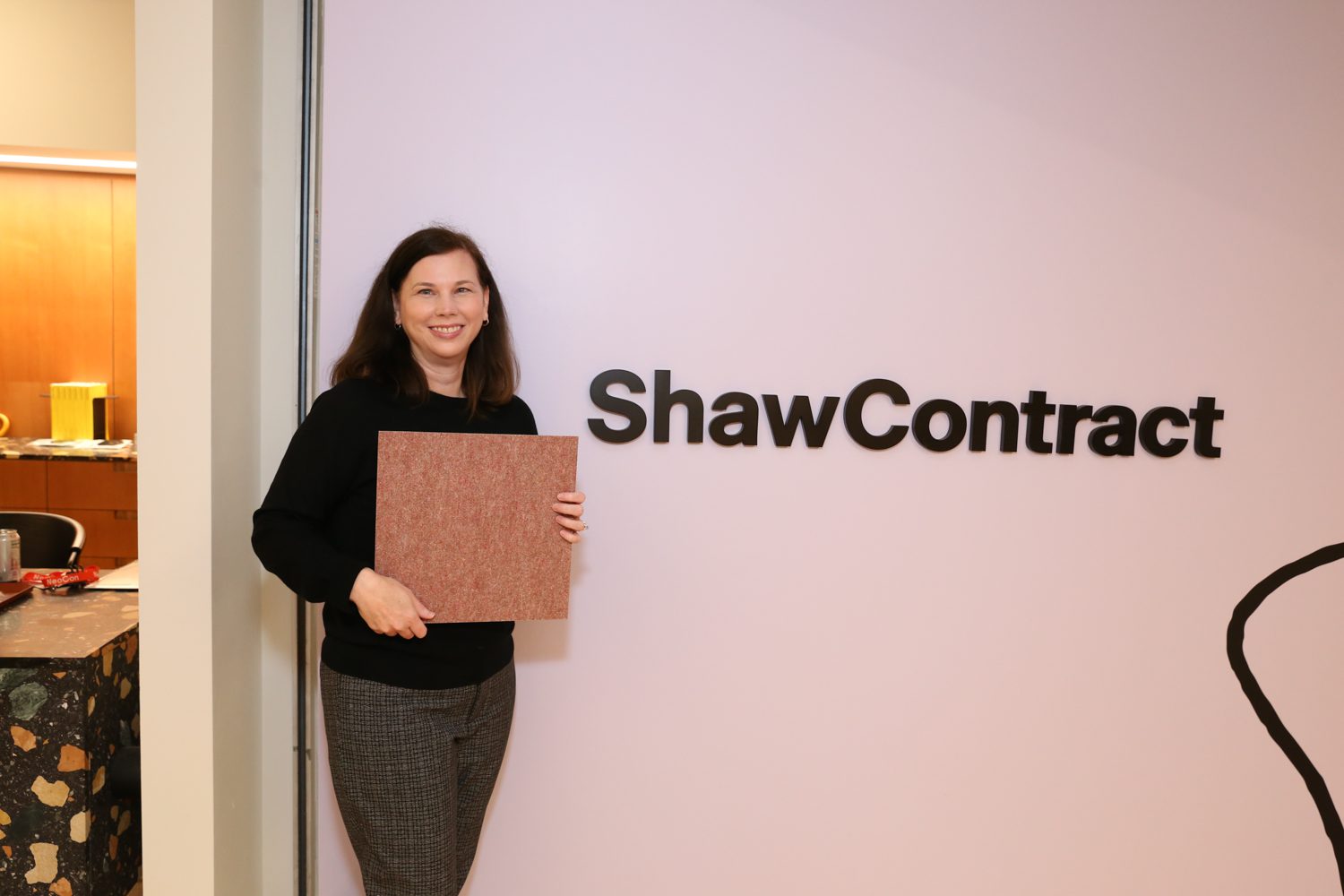 Ashley Ginn, design director community studio at Shaw Contract with the brand's BottleFloor made from 30% PET bottles. 