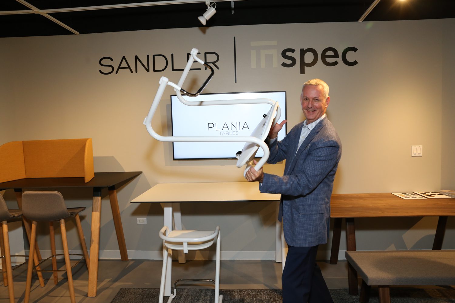 Rusty Wolf, director of sales at Sandler Seating, with the Plania adjustable table.