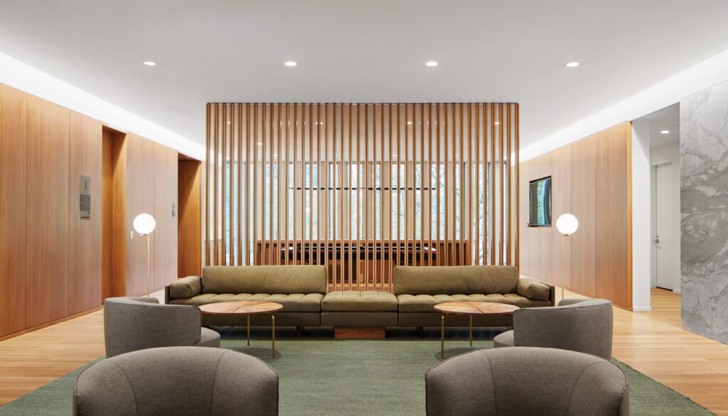 In the delegates’ lounge, a custom walnut screen backdrops BassamFellows’s sectional sofa and tables and Vincent Van Duysen’s Elain armchairs.