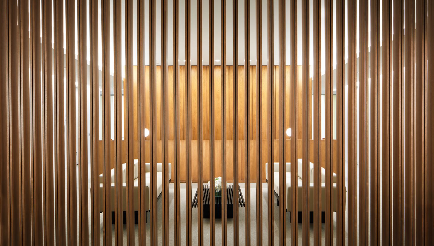In a screened reception area, leather-covered sofas face a slatted coffee table, all by Charlotte Perriand.