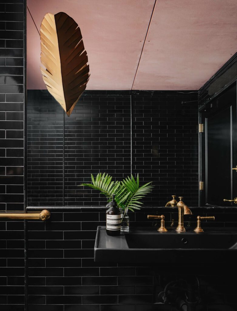 Restrooms are tiled by Fireclay and include pedestal sinks by Kohler and the Ada sink console by The Bath Outlet with faucets by Newport Brass and sconces by Shades of Light.