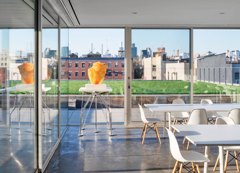 Sliding glass doors run between the green roof and penthouse, used for quiet work or events but that is zoned residential to host visiting artists.