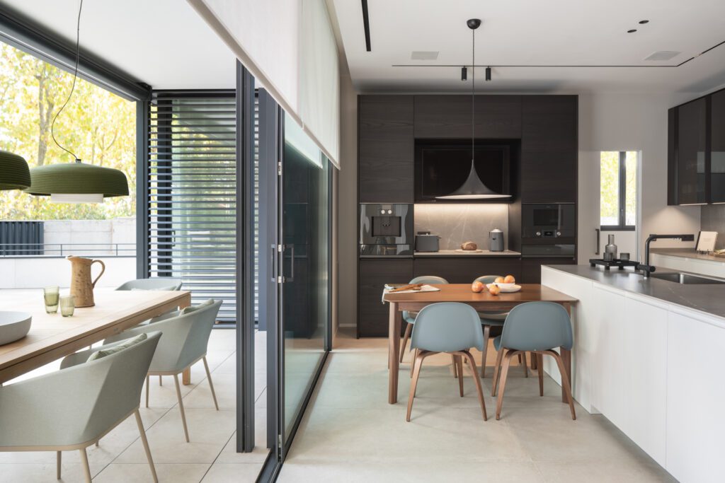 A sliding glass wall floods the kitchen with light and opens the space to the outdoors.