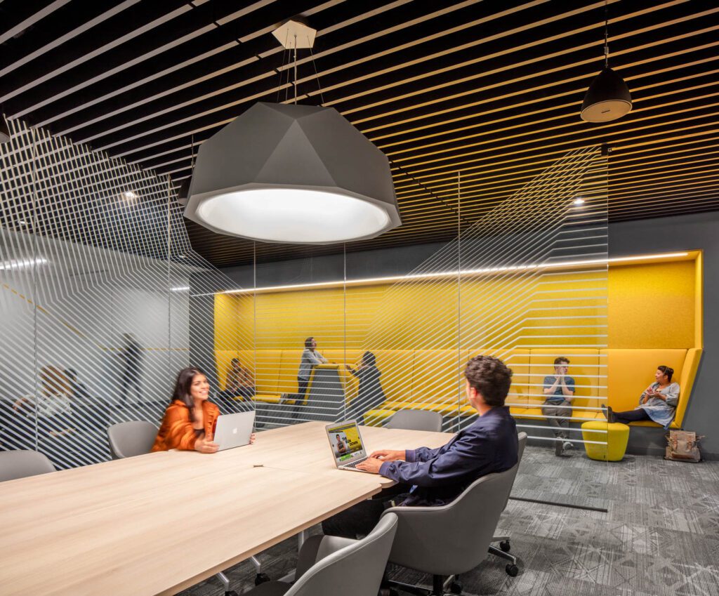 The student meeting and collaboration space is separated by clear partitions that allow for continued collaboration. Image courtesy of Magda Biernat.