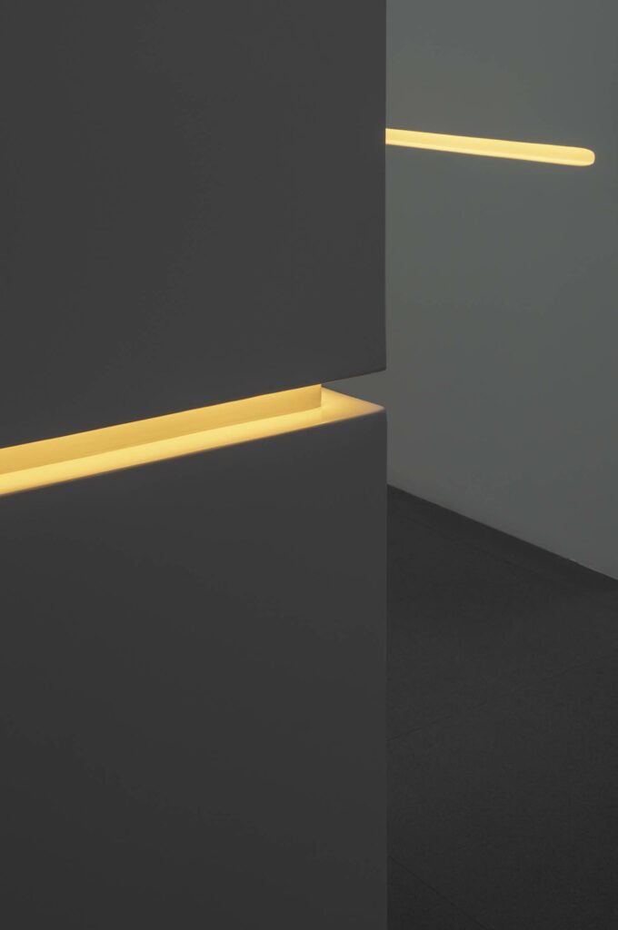 The yellow linear fixtures serve both as wayfinding and ambient light.