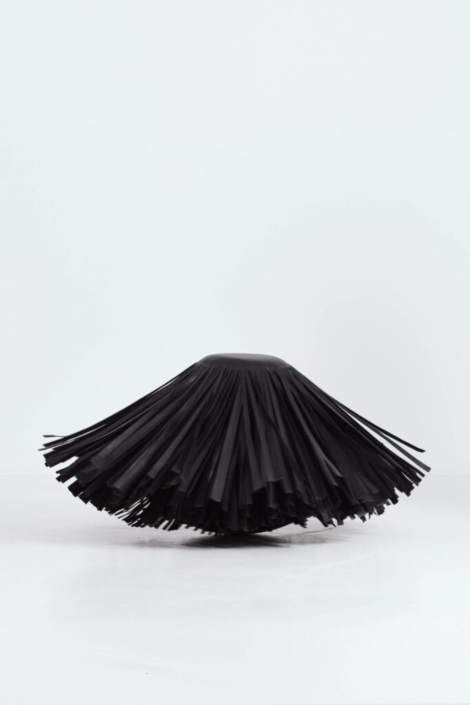 Rows of hanging leather tassels conceal drape across the Hypnotic stool.