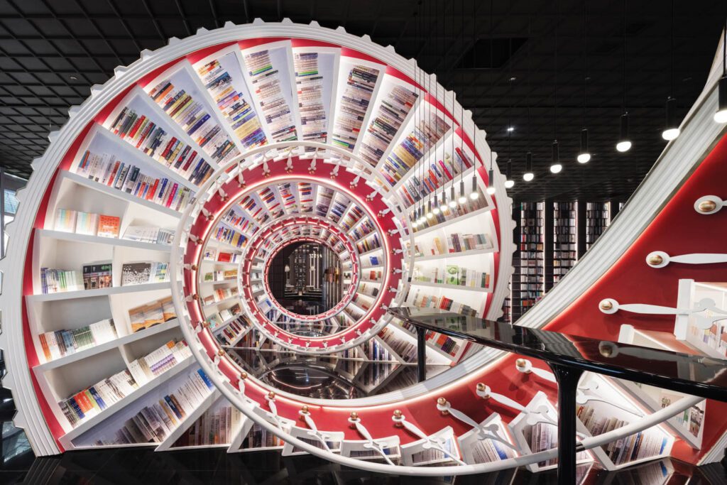 At Shenzhen Zhongshuge bookstore in China by X+Living, actual volumes along with peel-and-stick representations line a 122-foot-long spiral resembling a staircase on its side. 