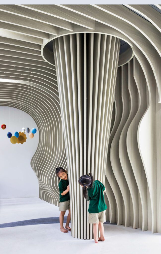 LABORATORY FOR VISIONARY ARCHITECTURE: The natural forms of trees inspired the plywood ribbing around columns at Eco Kindi, a kindergarten school in Vinh, Vietnam. Photography: Hiroyuki Oki.