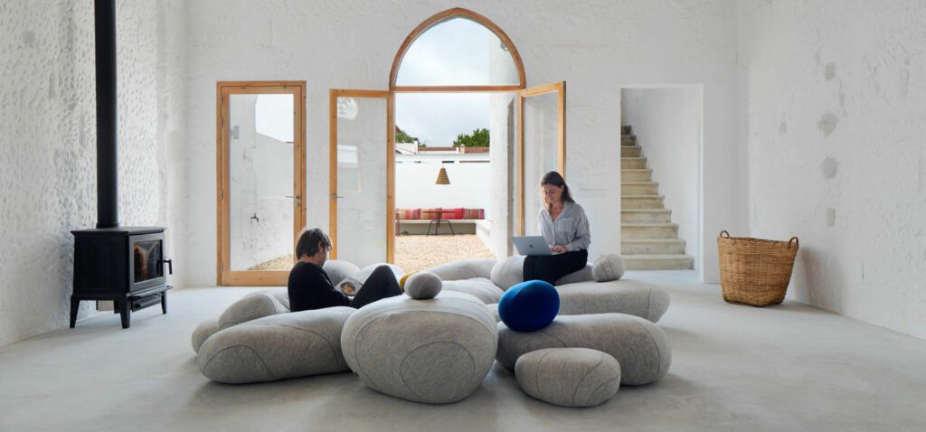 Oversized wool Livingstones poufs by French design studio Smarin surround the fireplace, like an array of pebbles on a beach. 