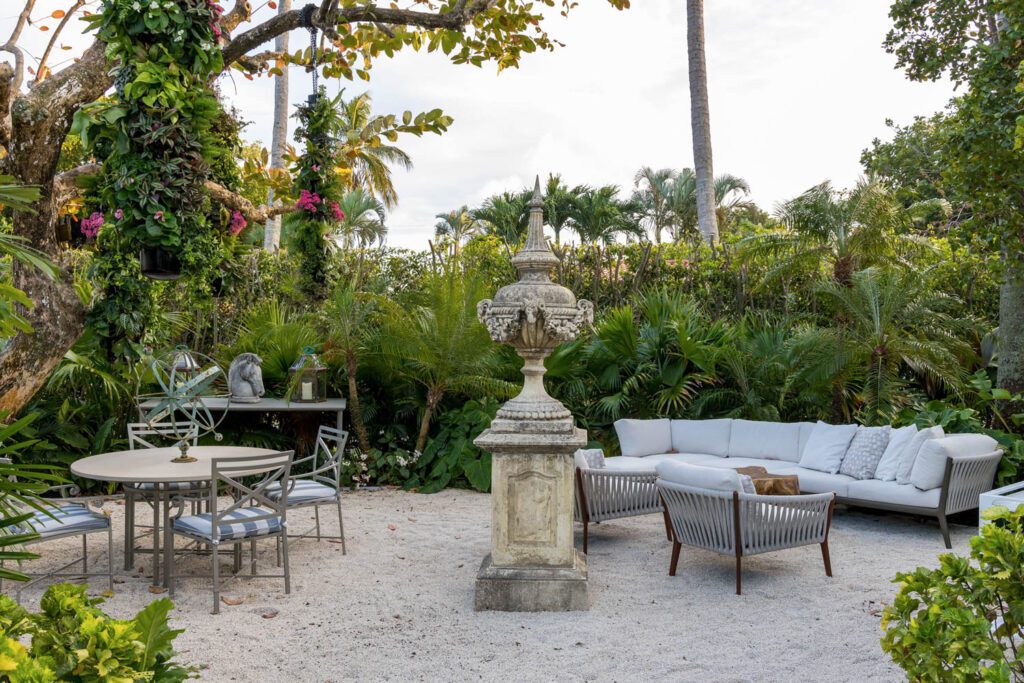 A sculpture is the center of this outdoor lounge area complete with lounge, table, and chairs