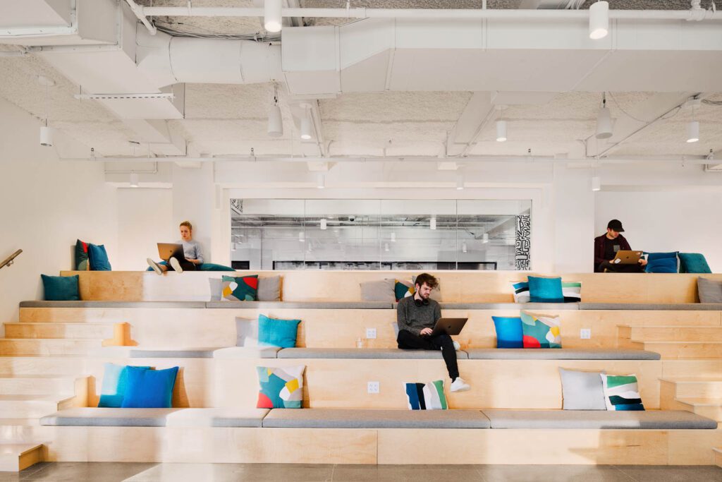 Employees work on a bleacher-like community space