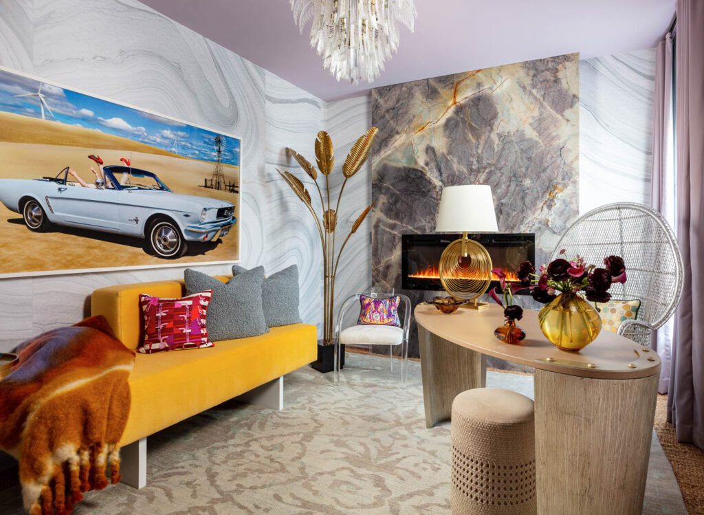 Textural wallpaper in a small bedroom with a yellow day bed and small desk