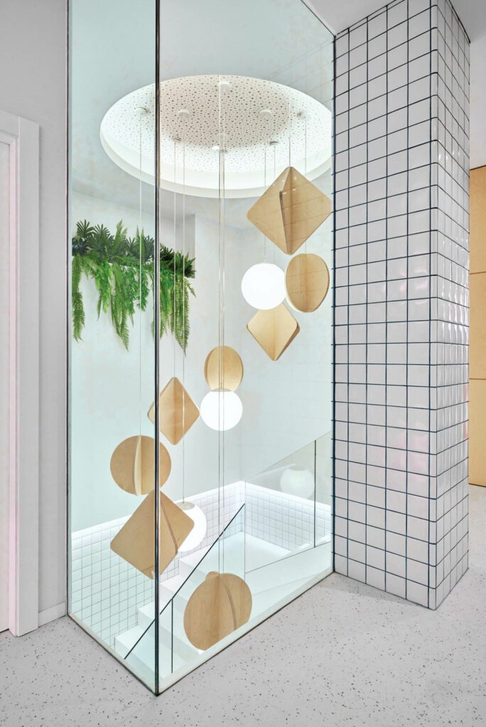 A custom birch-plywood chandelier inspired by mobiles hangs above the stairway leading from the patient-care areas to the basement for staff use.