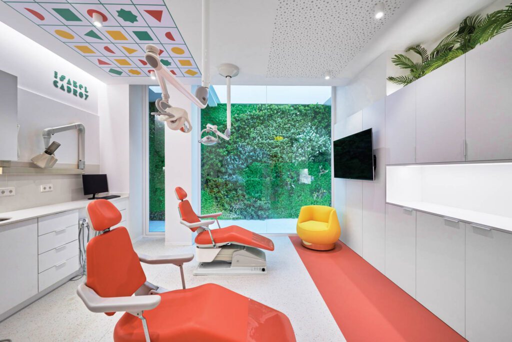 Patient chairs continue the palette in the treatment rooms, which overlook an artificial vertical garden set below a skylight. 