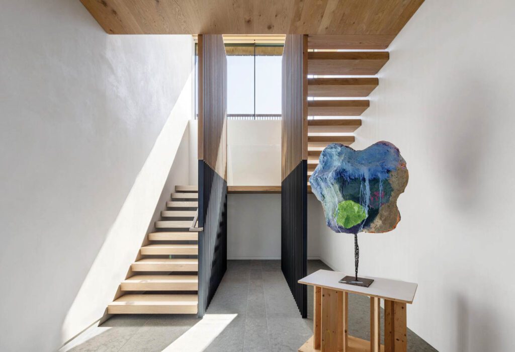 Flooded with light, this floating staircase, one of three in the house, also provides an ideal spot for the display of large artworks like this mixed-media piece by Franz West.