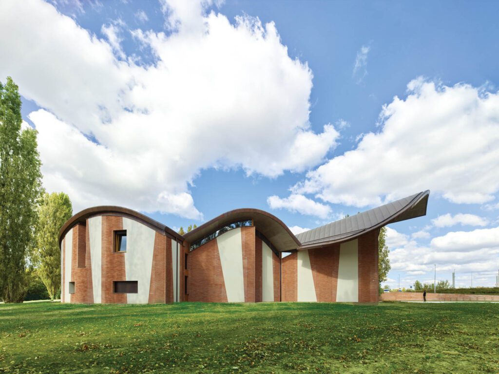 The sawtooth brickwork cladding San Giacomo Apostolo Church, a ground-up Catholic parish complex in Ferrara, Italy, by Benedetta Tagliabue-EMBT, nods to the carved facade of a 15th-century palazzo nearby, for an appearance that’s both modern and historic.