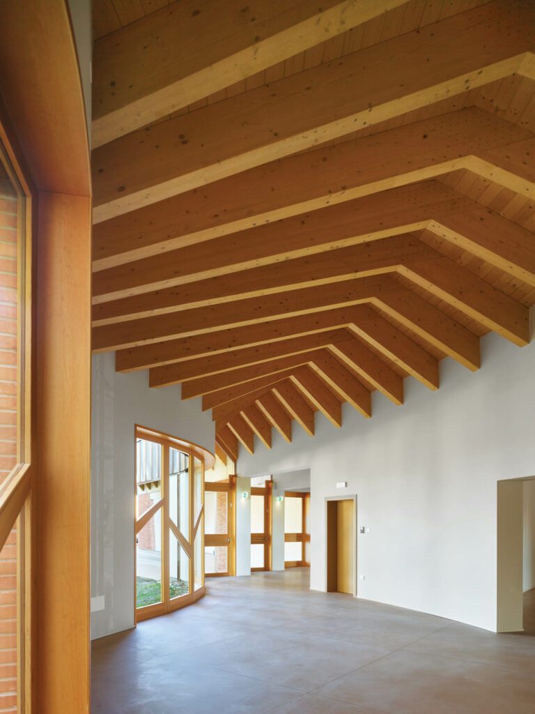 A corridor, its fir ceiling vault and window frames referencing the site’s surrounding poplar trees, leads from the church to the annex containing a parish hall and classrooms.