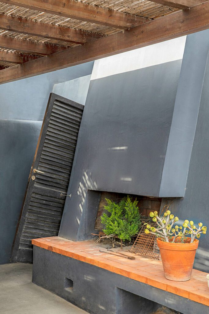 An outdoor fireplace built into the sloping wall at the back of the house.