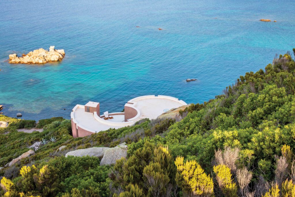 The sophisticated curved form of Casa Rotonda by Cini Boeri (1924-2020) blending effortlessly into the wild Sardinian landscape.