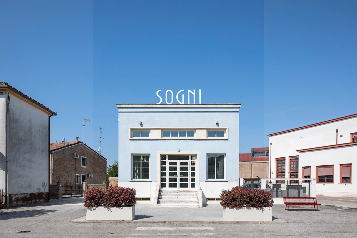 A pale blue facade on a cubelike building in town. 