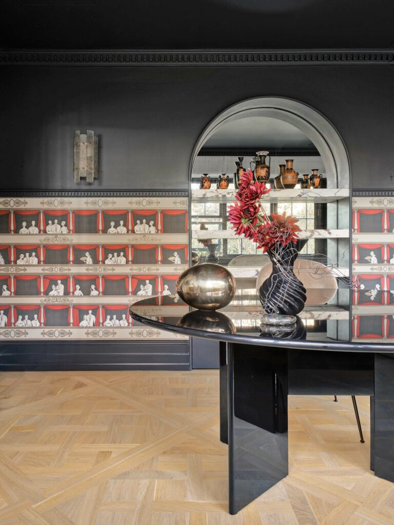 Piero Fornasetti’s Teatro wallpaper clads the study, where a brass egg sculpture and Joel Escalona’s Miss Jolie ceramic vase alight on an Antella desk by Kazuhide Takahama.