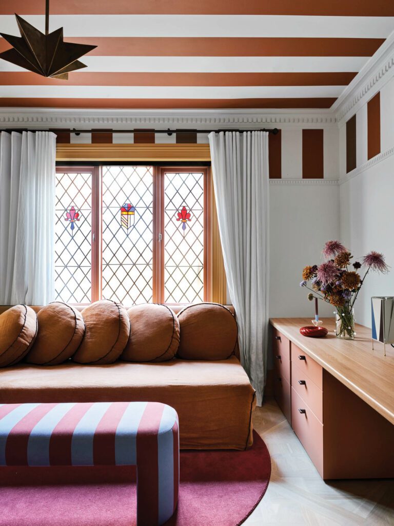 In the playroom, the sofa (with a machine-washable slipcover) and rug are custom; a Greta Grossman B-4 table lamp perches on a custom desk.