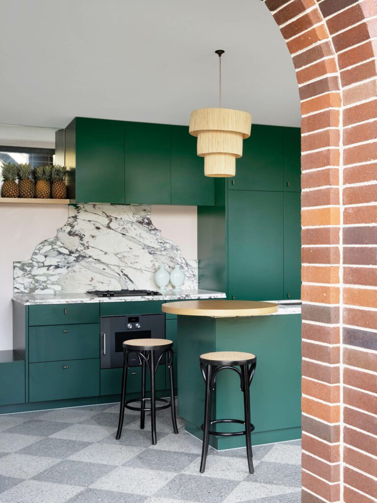 A Brescia Capria backsplash brings an artful note to the tennis house kitchen, furnished with Thonet cane-seat stools.