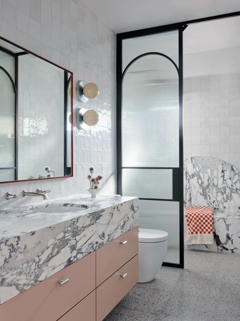 Boldly veined Brescia Capria marble animates daughter Annabelle’s bath, with custom mirror.