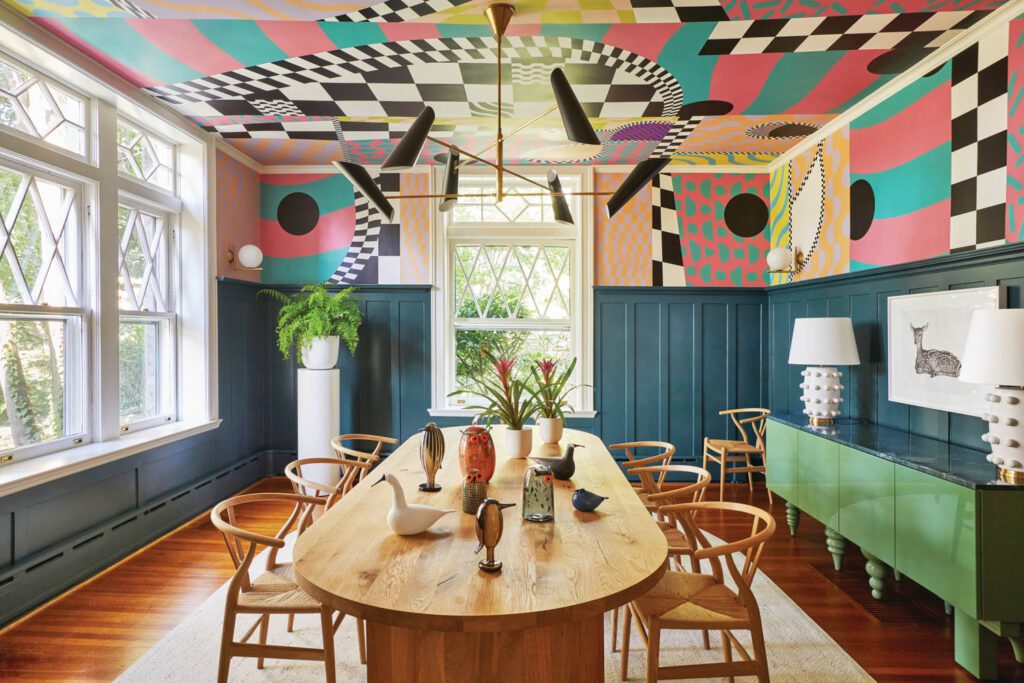 In the dining room, wallpapered in Borderline Chinoiserie by Voutsa, a Kiki Smith print, Fawn, hangs over a Jaime Hayon credenza; a flock of mouthblown glass birds adds height and interest to the oak table by Philipp Mainzer.