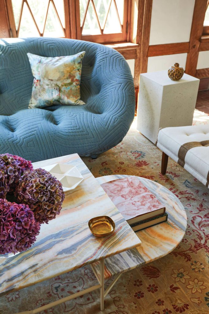 In the sunroom, a Bouroullec Brothers Ploum sofa joins an Iacoli coffee table featuring a custom top in onyx from Artistic Tile.