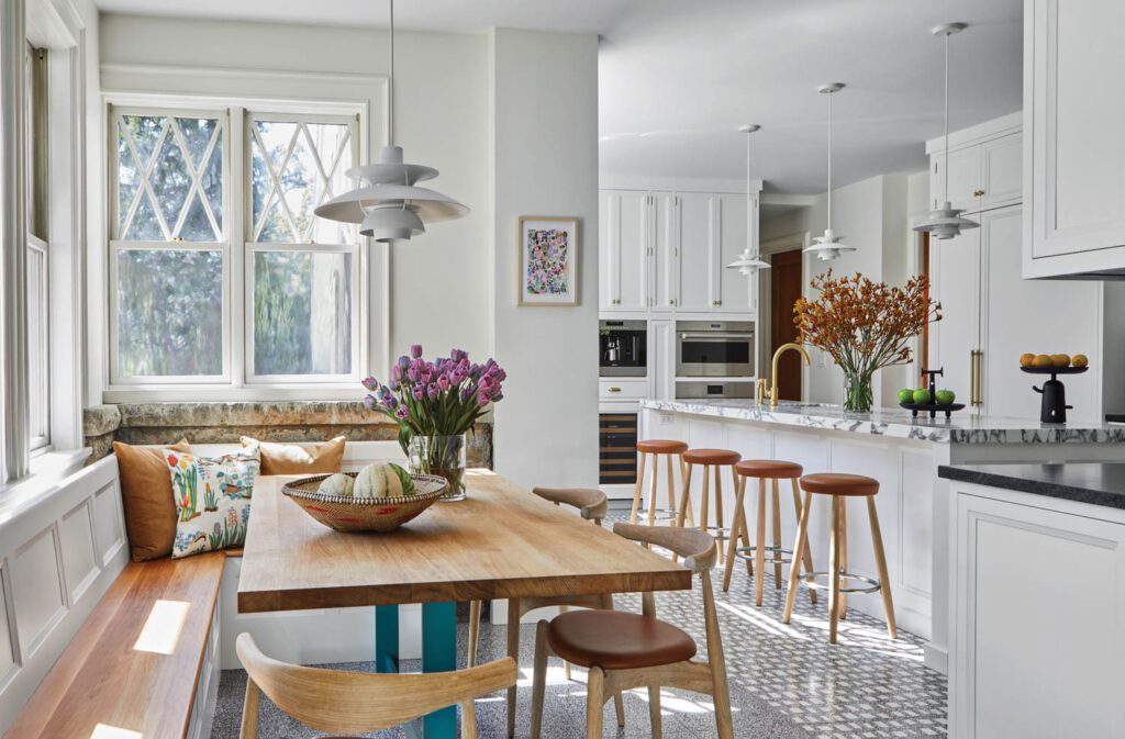 In the kitchen, with Shaker-style cabinetry from Bilotta, Dufner Heighes added a built-in banquette to maximize space; the chairs and stools are by Hans Wegner.