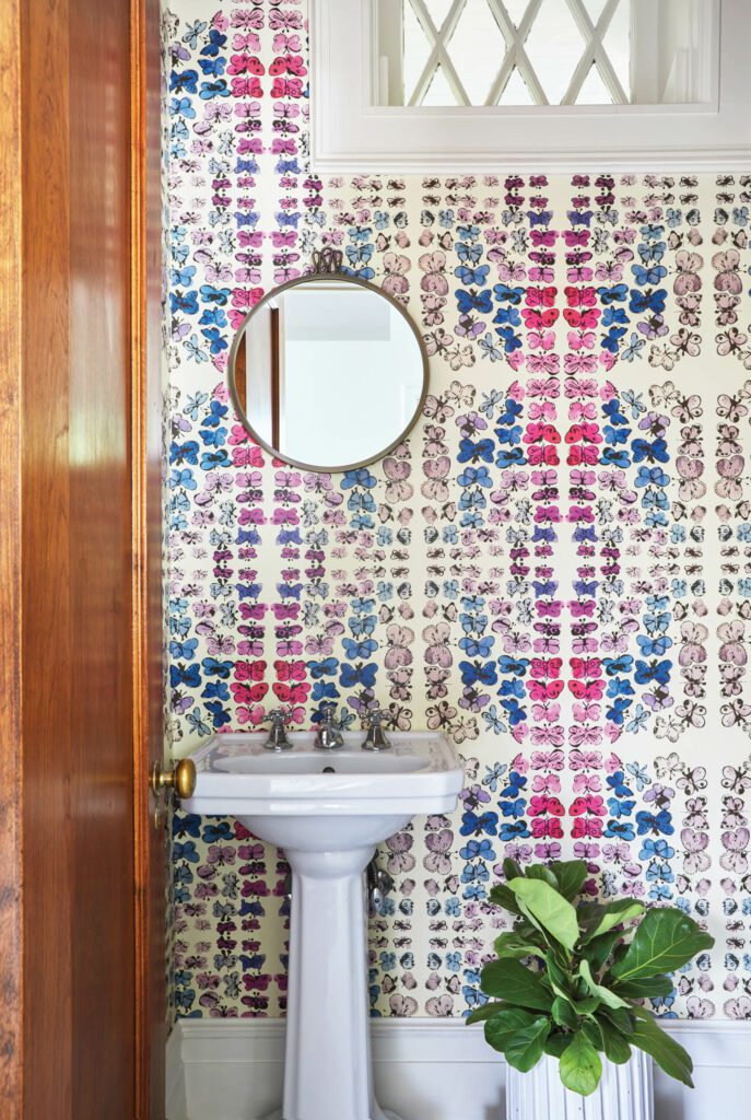 Flavor Paper’s Happy Butterfly Day wallpaper and a Gio Ponti mirror bring zing to a powder room.