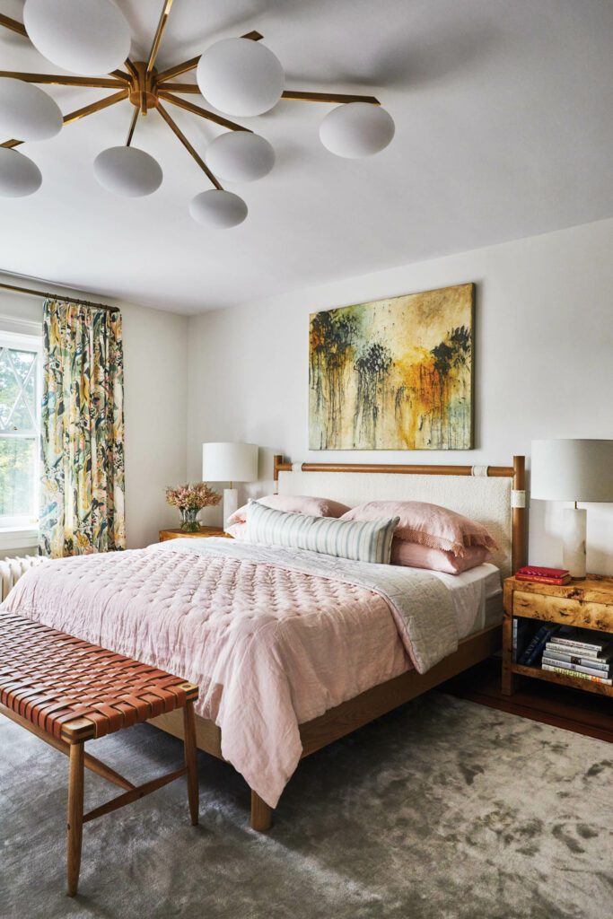 The primary bedroom is furnished with a Lawson-Fenning Chiselhurst bed, custom Simple bedside tables by Dufner Heighes, a Michael Robbins Ranger bench, and a painting by Bruce Tolman.