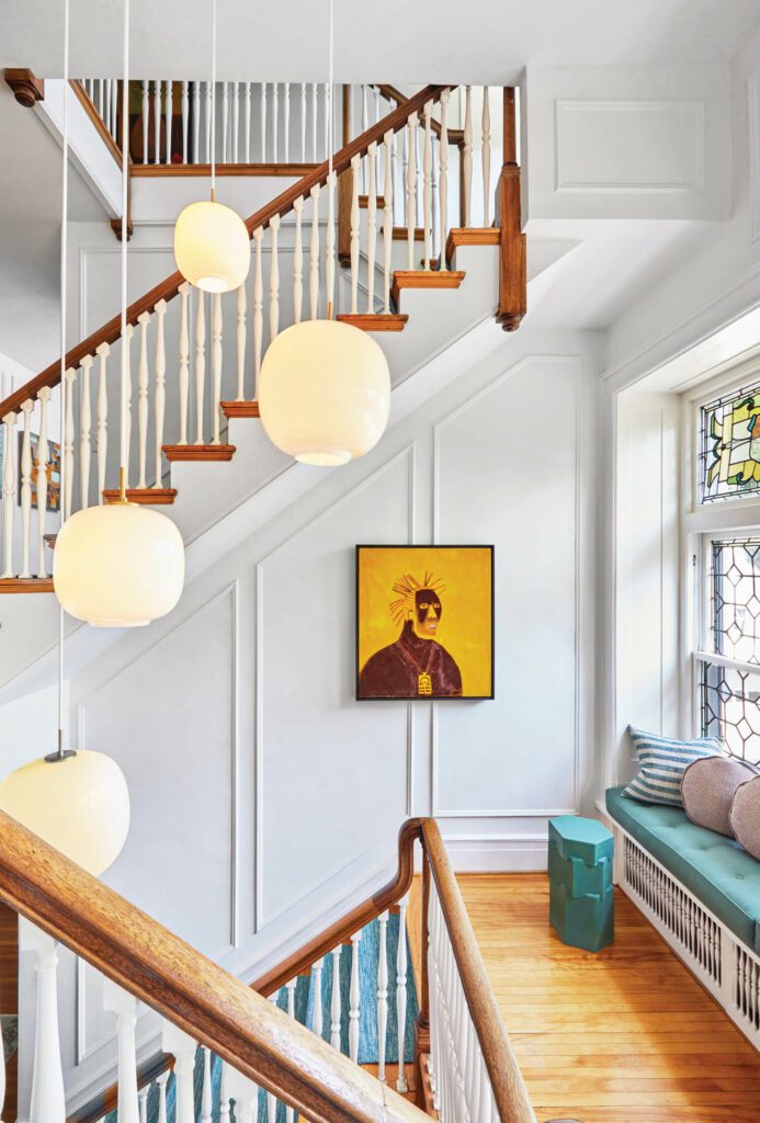 Katie Hammond’s Ol’ Dirty Bastard accents the stair hall, illuminated by Louis Poulsen pendants.