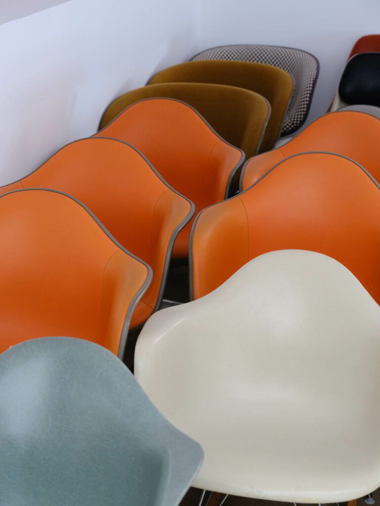 The Eames Shell Chair in orange, blue, white, and brown. 