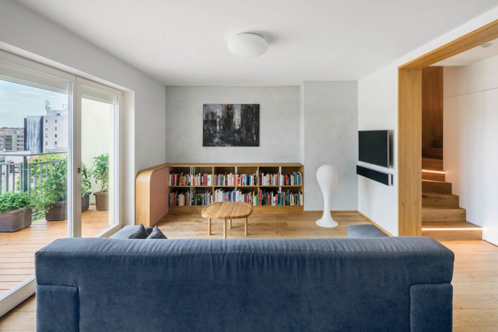 a bookshelf across from a blue couch in a living room