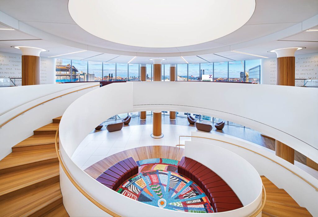 Rift-cut white oak forms the stair’s handrails, treads, and risers and clads columns, while leather covers the custom modular bench.