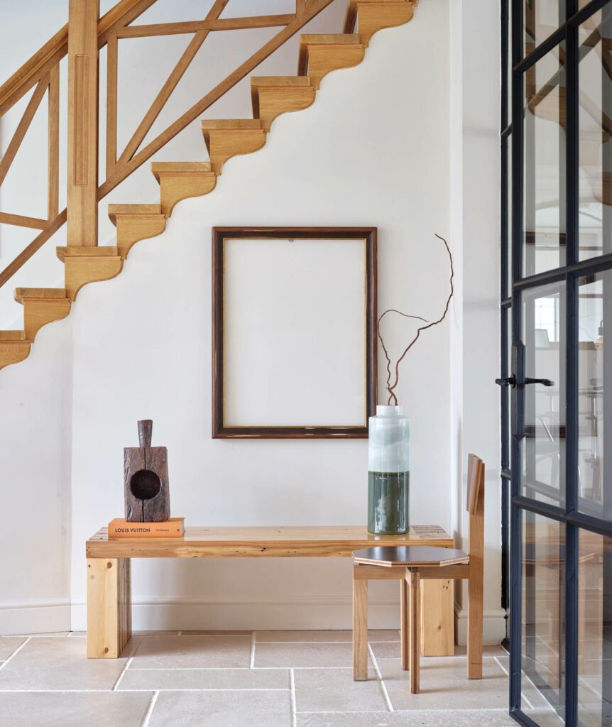 A custom bench of wood reclaimed from the stable stands in the foyer of the residence.