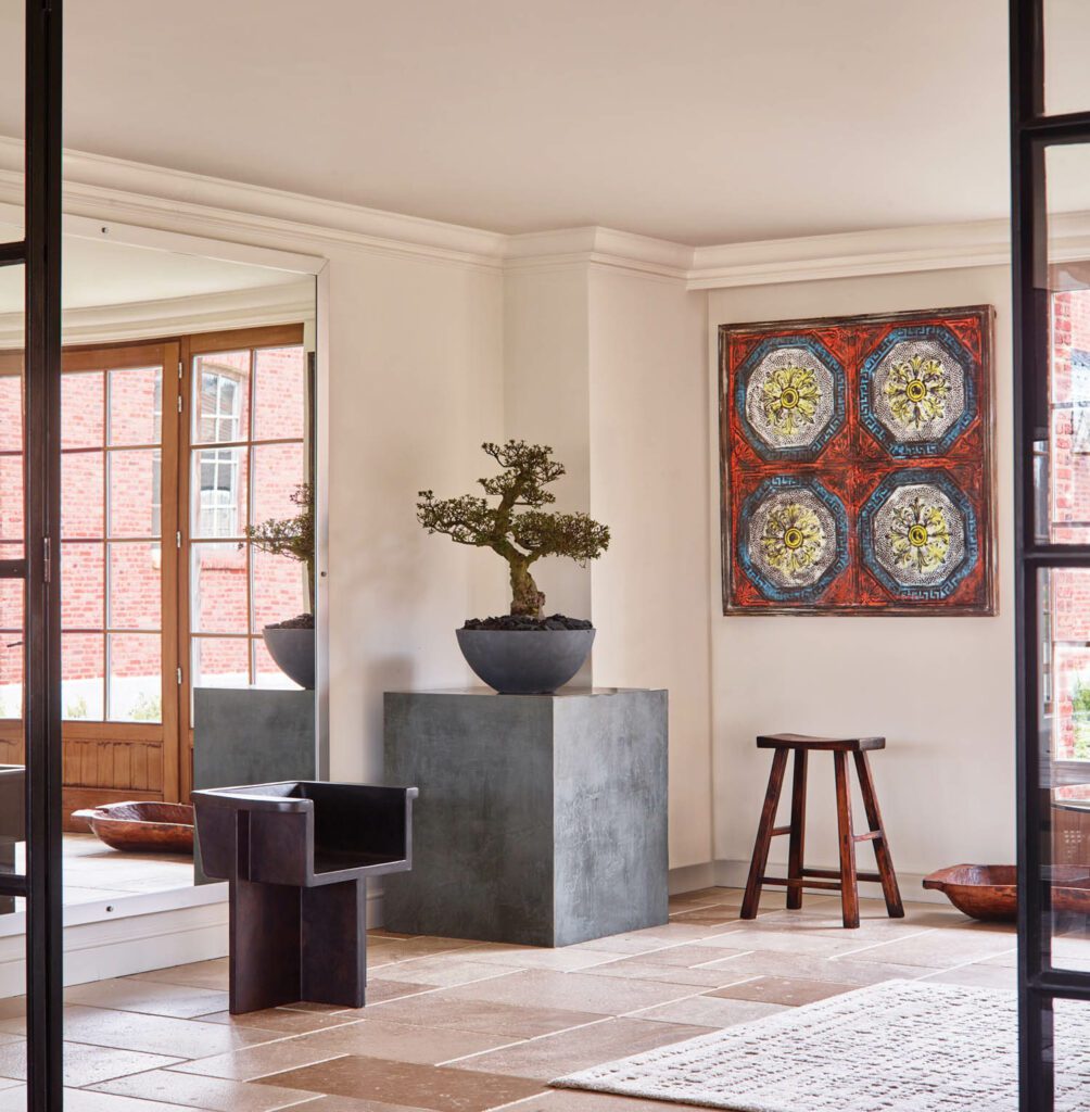 An antique Asian rosewood stool and a fiber-concrete chair by Kristian Sofus Hansen and Tommy Hyldahl meet a 280-year-old Japanese azalea bonsai on other side of the foyer.