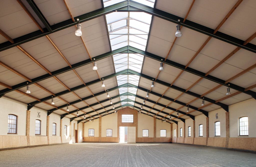 The indoor riding arena, completed in 2012 by Architectenbureau Kristel Caes, occupies the same structure as the living quarters.